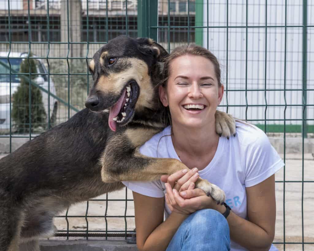 Smiley woman ina shelter with a big dog